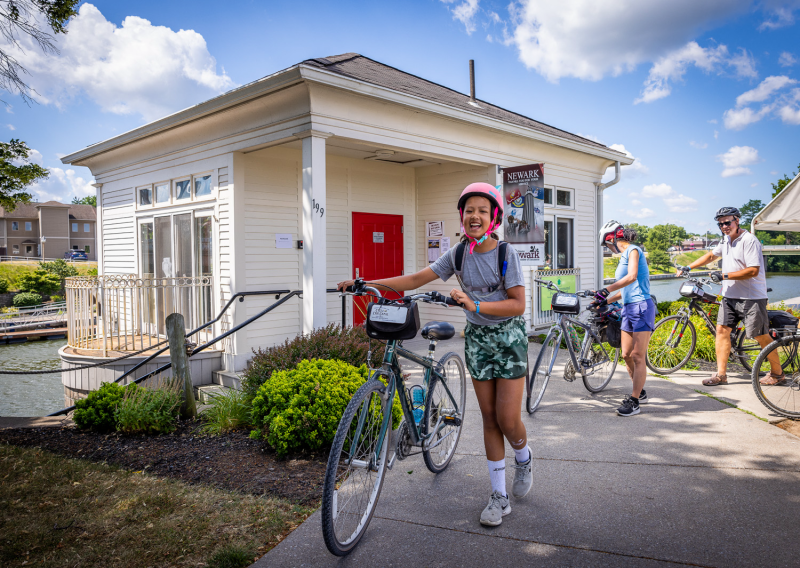 A child walks their bike along a path.