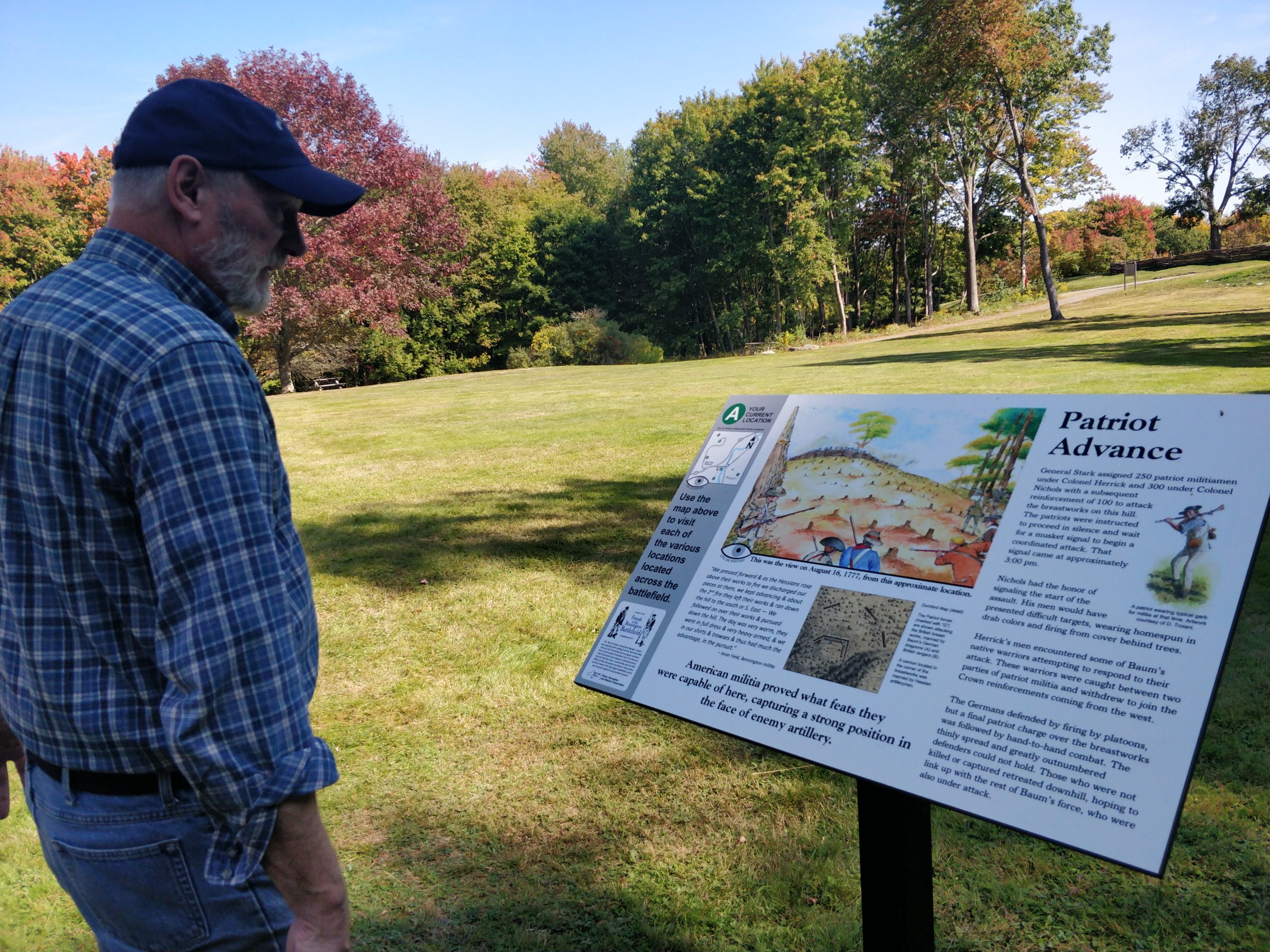 A man reads an interpretive Sign at Bennington Battlefield