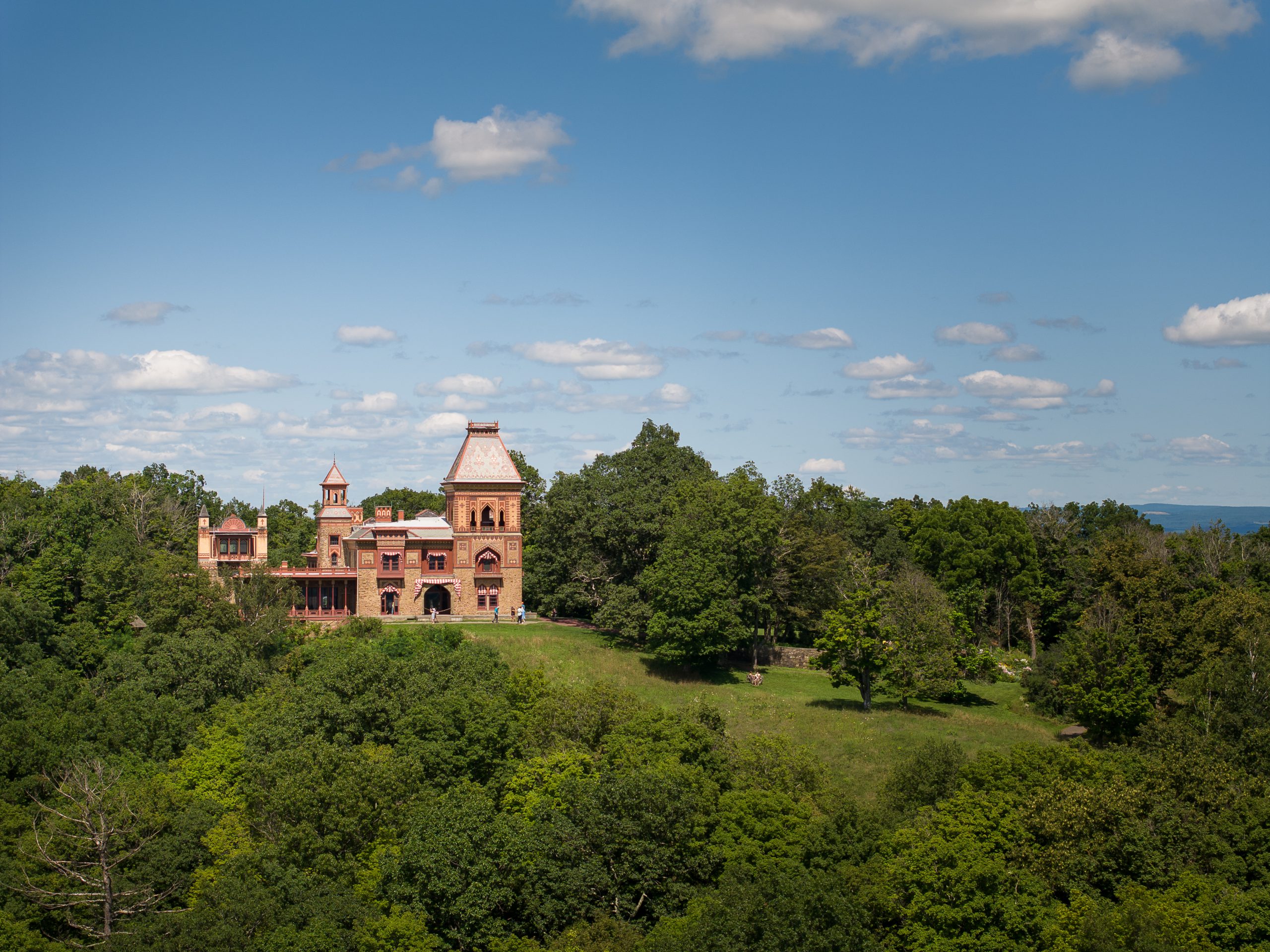 An aerial view of Olana State Historic Site, showing a large estate atop a wooded hill.