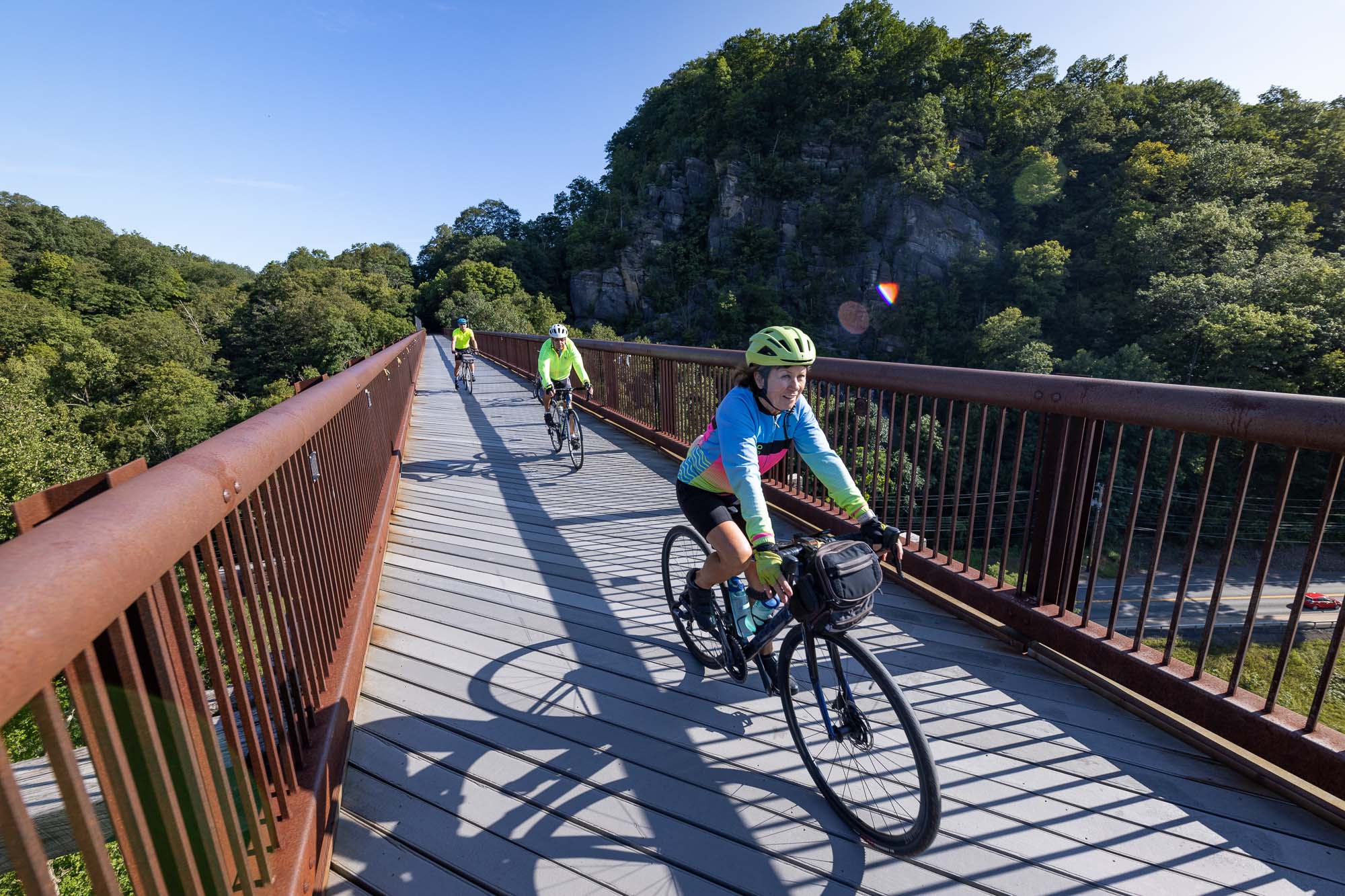 A woman in blue cycles across the Rosendale Trestle.