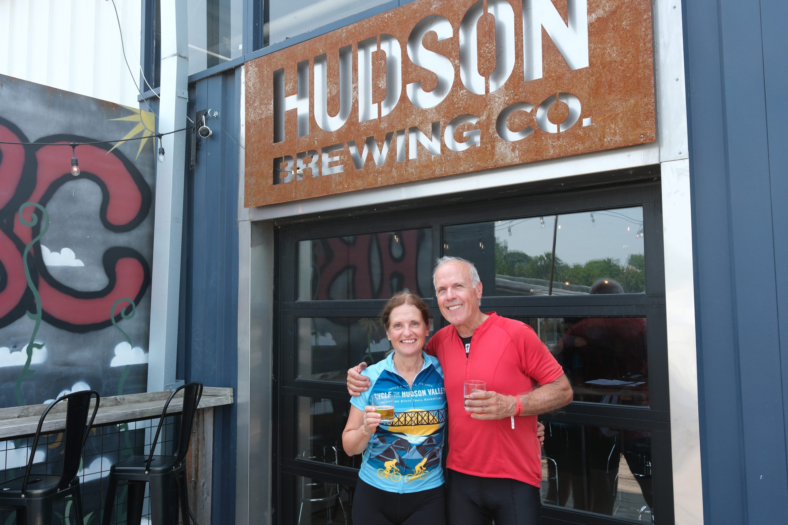 A couple drinks beer at Hudson River Brewing, a Bike Friendly Business.