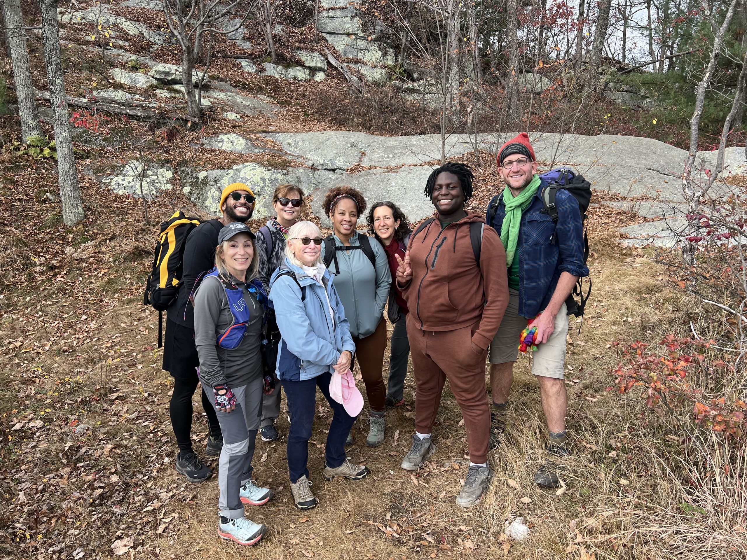 A group of hikes pose for a photo in the woods.