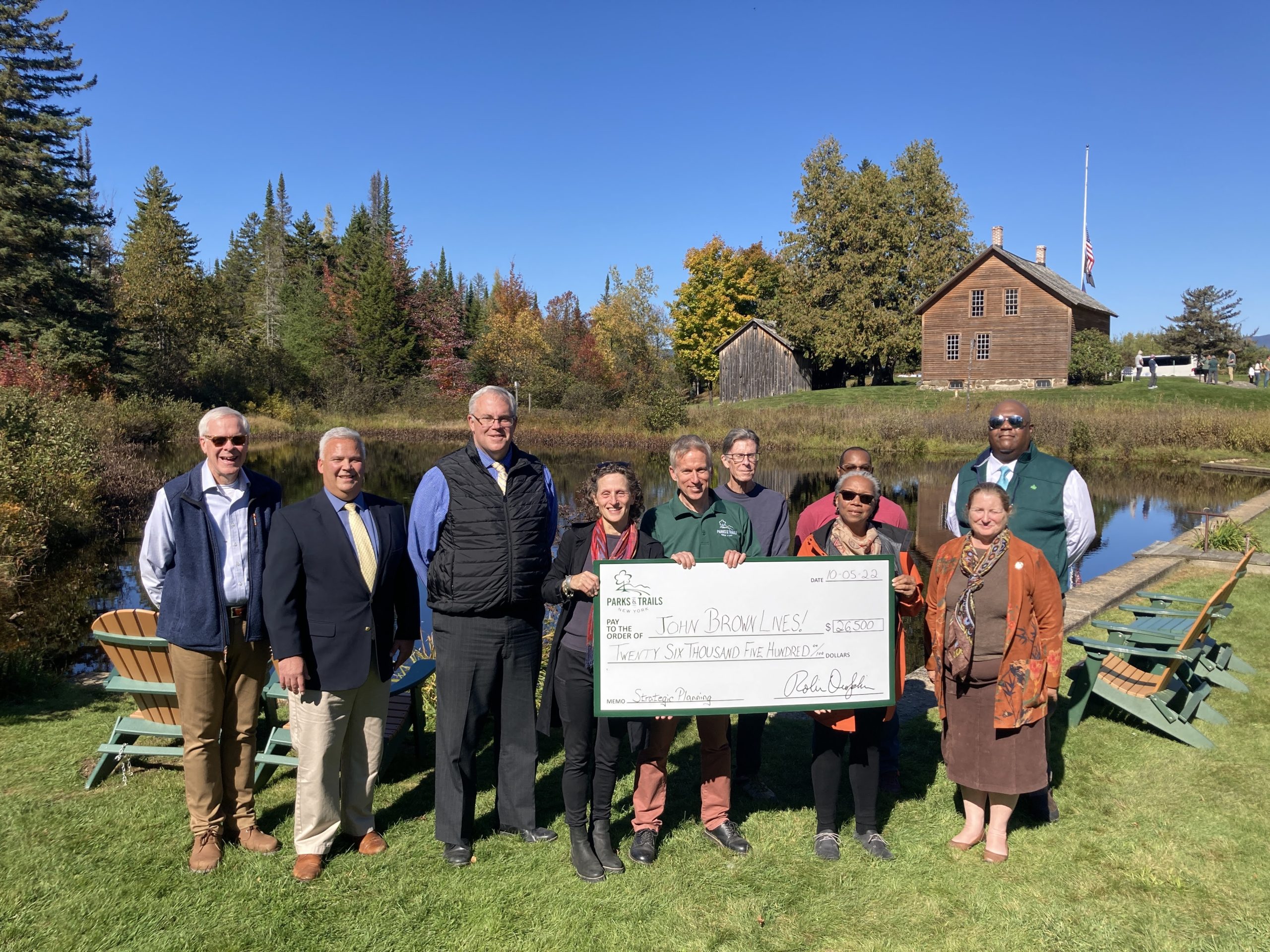 A group poses for a photo, holding a big check for the amount of $26,500 to the friends group John Brown Lives!