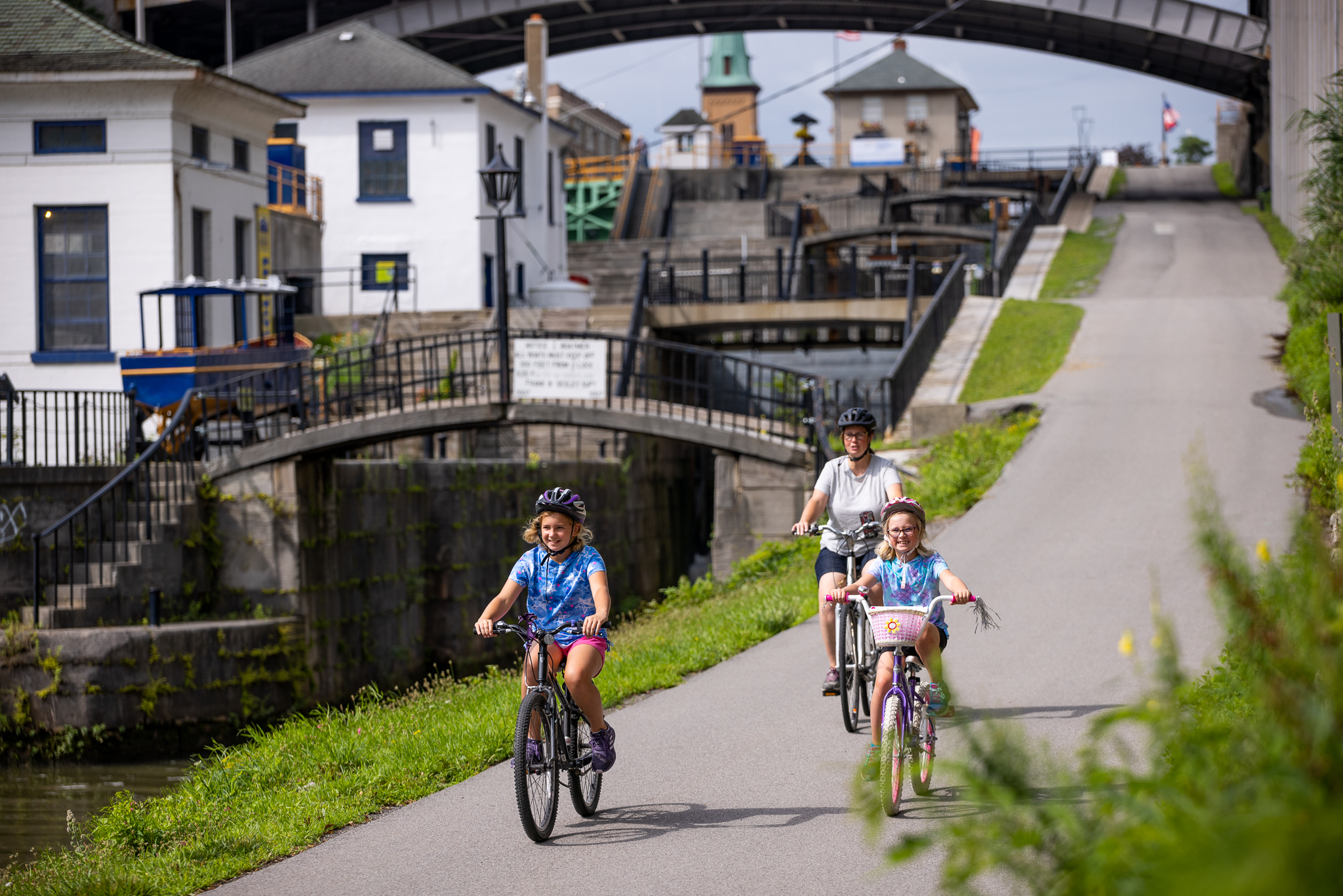 Two children and a woman cycling along the Erie Canal at Lockport.