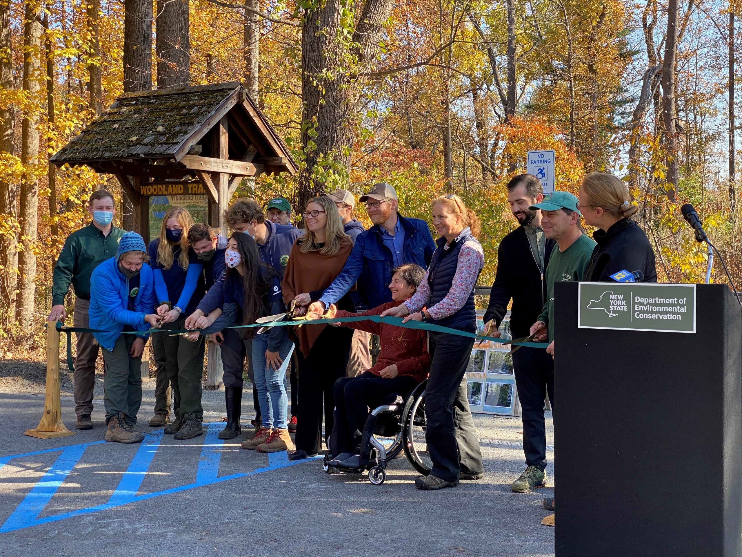 A group of people cut a ribbon to unveil park improvements.