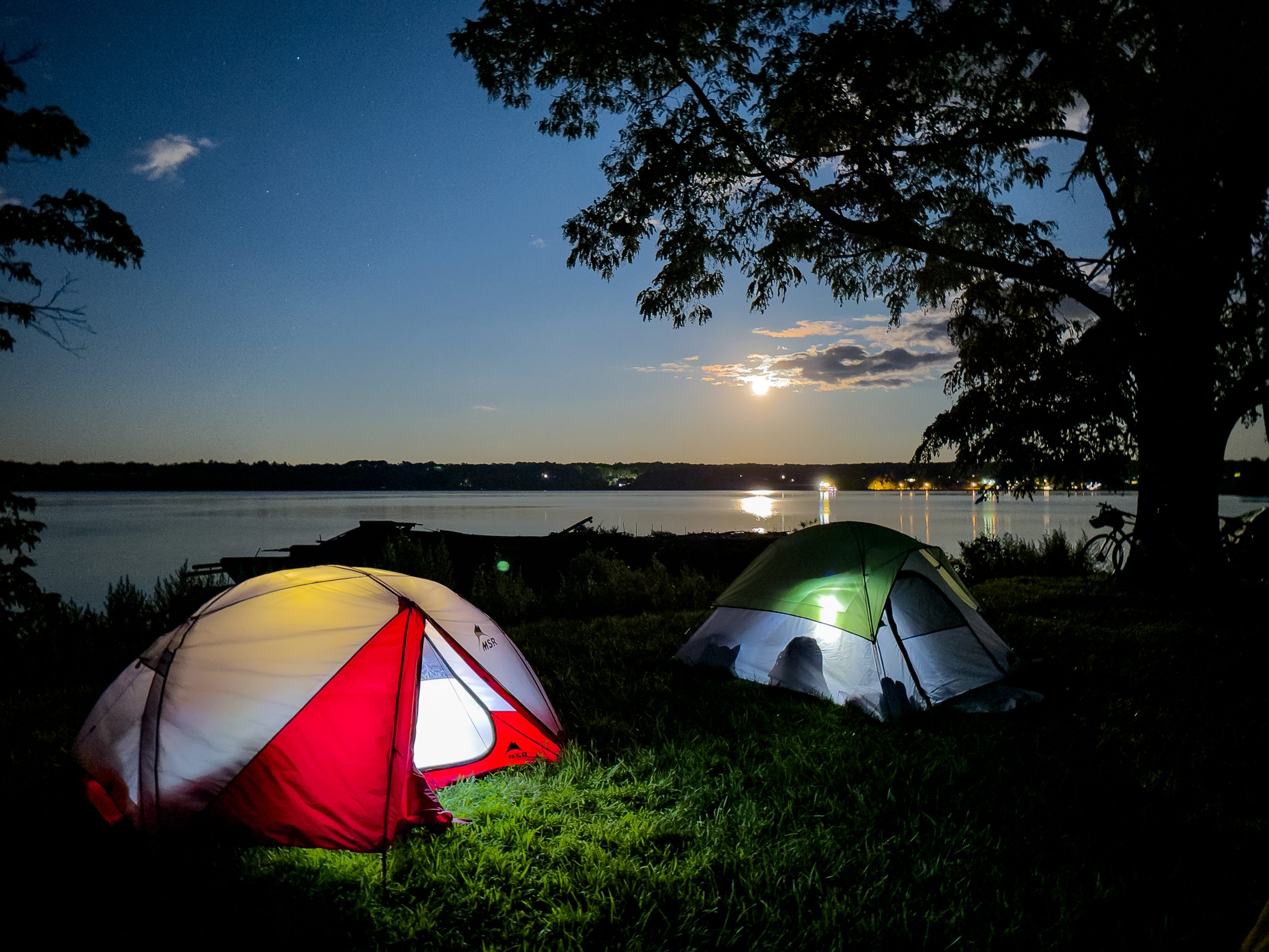 Two camping tents underneath a starry night sky.