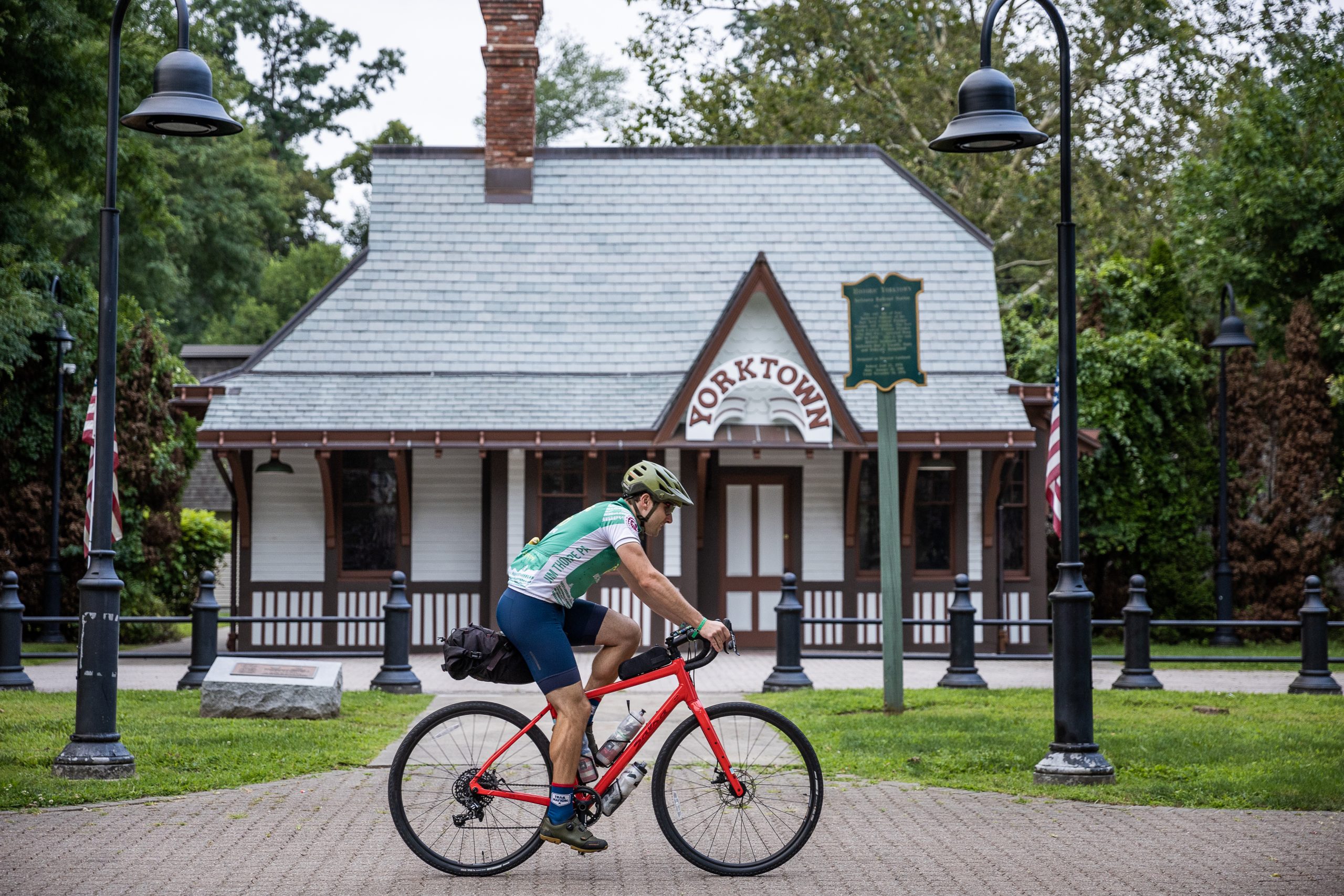 Two cyclists ride along a pedestrian bridge.