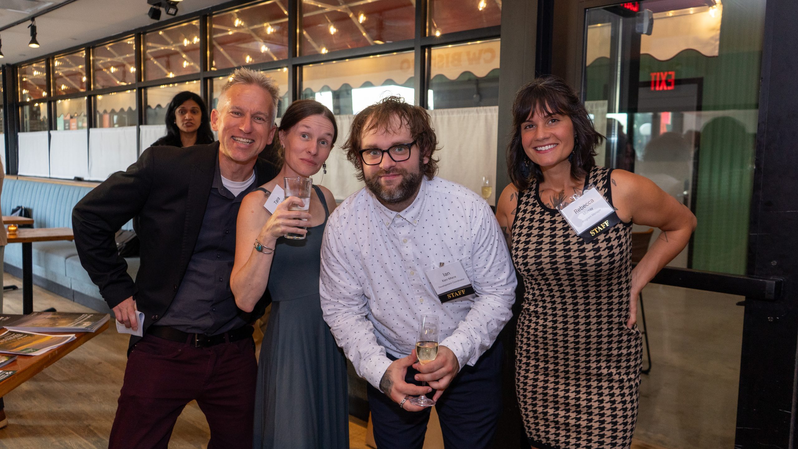 A group of event-goers smile as they pose for a photo.