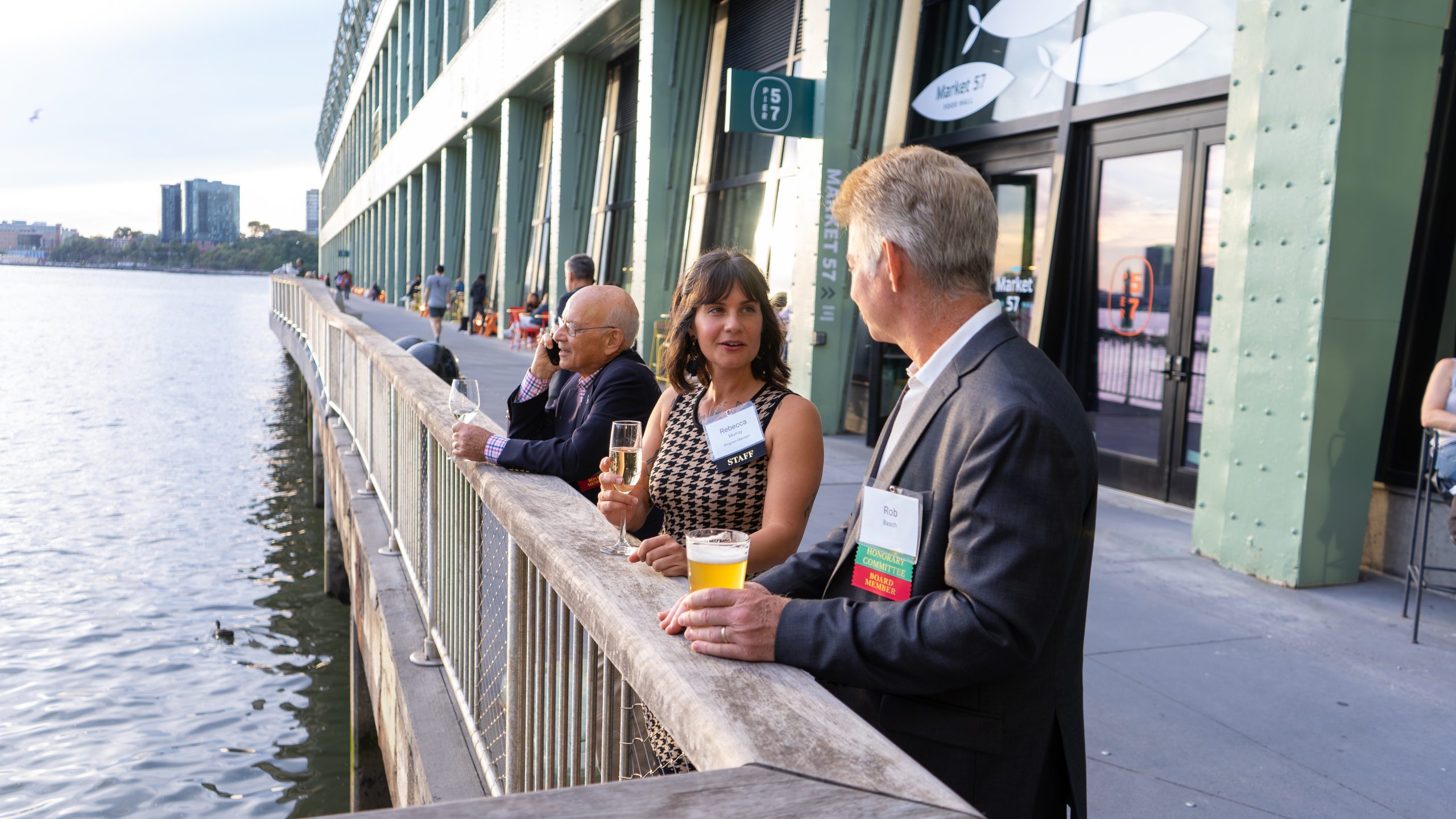 Two event-goers speak along the pier of the Hudson River.