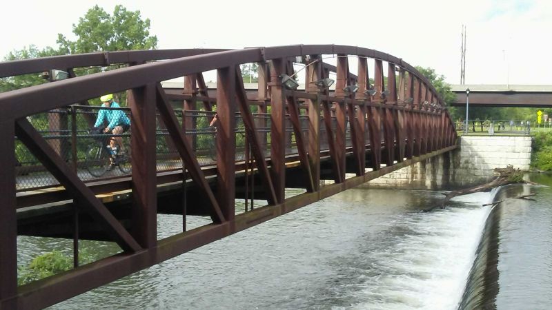 A cyclist rides past a handmade sign with a heart and the word cyclists.