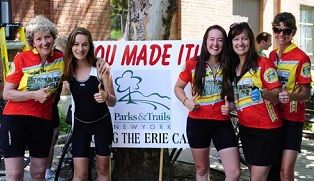 A cyclist rides past a handmade sign with a heart and the word cyclists.