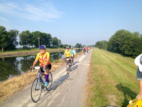 A cyclist rides past a handmade sign with a heart and the word cyclists.