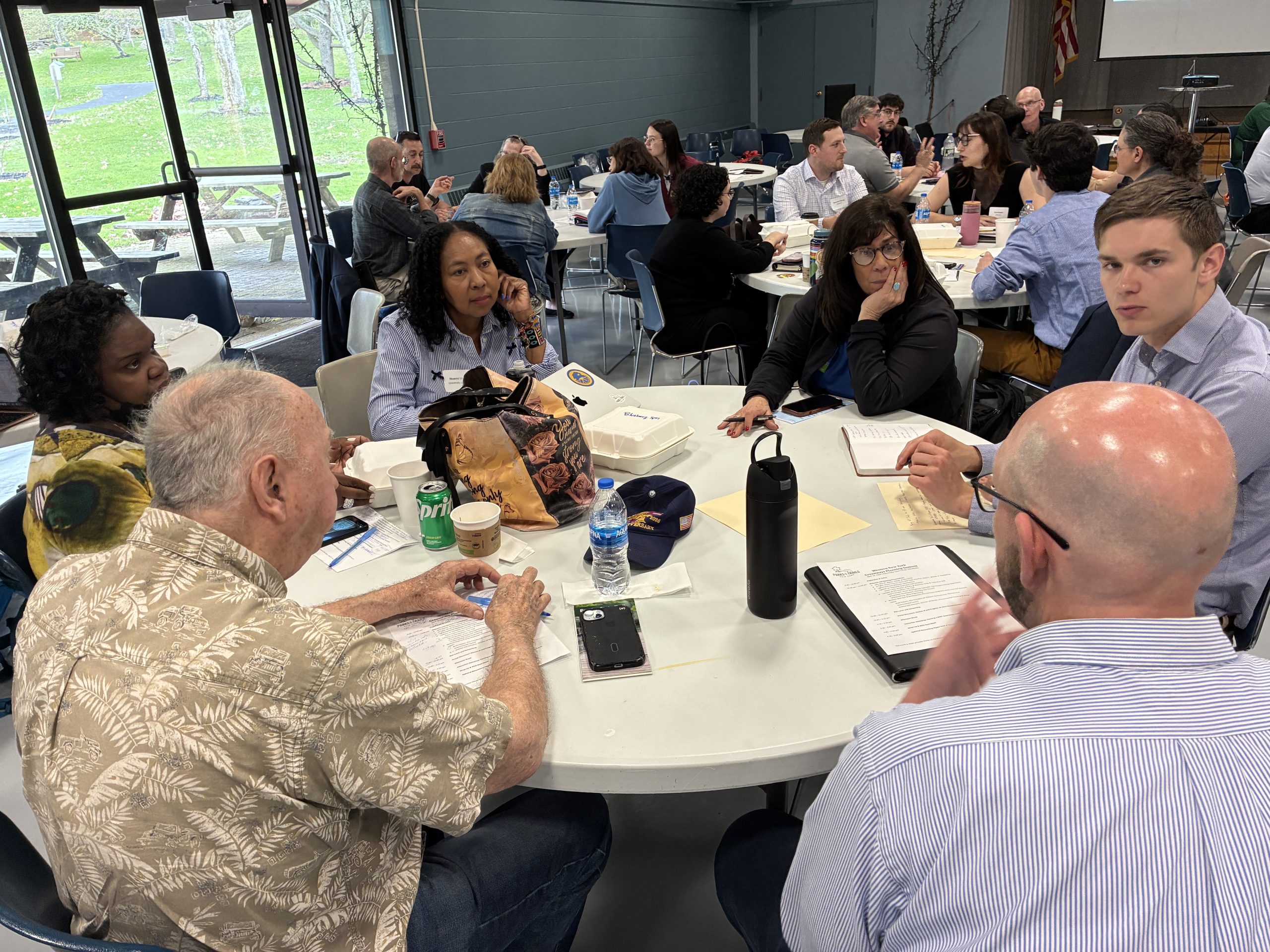 Group of people gathered around a table in conversation at a conference.