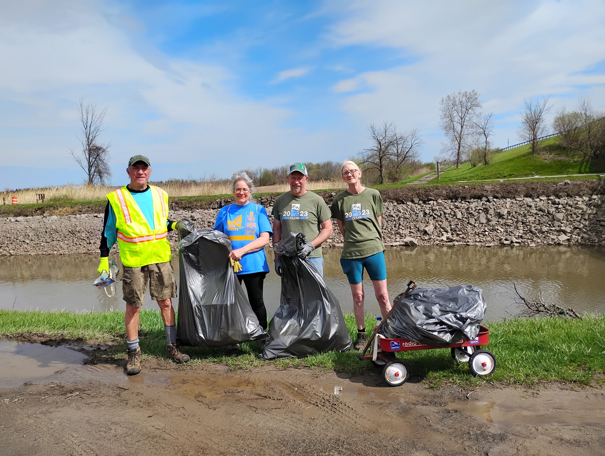 A group of volunteers pose for a photo holding trash bags.
